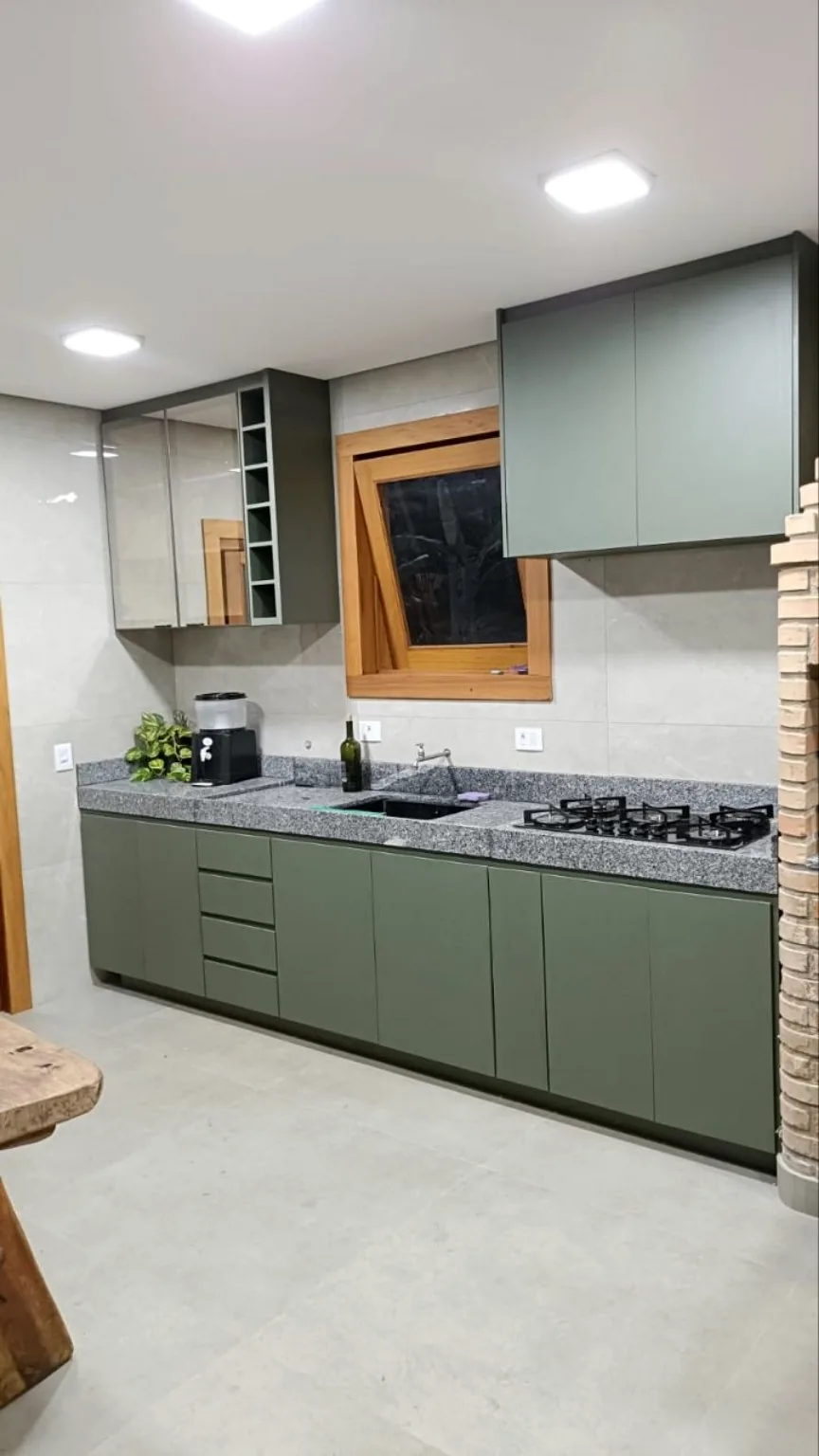 Cozinha planejada verde com bancada em granito